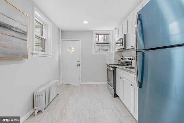 2839 Winton St, Philadelphia, PA 19145 - kitchen with stainless steel appliances, radiator, white cabinets, tasteful backsplash, and recessed lighting