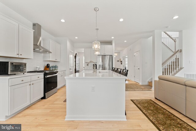 9400 Kinnerton Dr, Midlothian, VA 23112 - kitchen featuring gas range, wall chimney exhaust hood, stainless steel refrigerator with ice dispenser, white cabinets, and light wood finished floors
