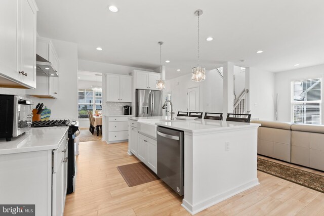 9400 Kinnerton Dr, Midlothian, VA 23112 - kitchen with stainless steel appliances, under cabinet range hood, white cabinets, a chandelier, and recessed lighting