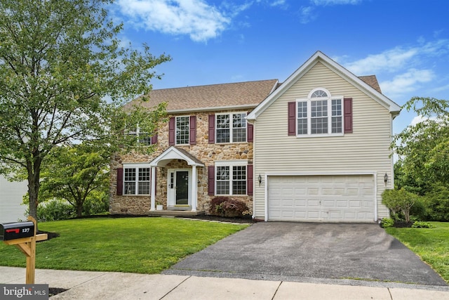 127 Watch Hill Rd, East Fallowfield Township, PA 19320 - view of front of home with stone siding, asphalt driveway, an attached garage, and a front yard