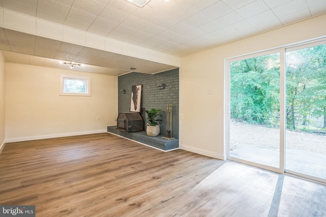 27136 Dogwood Ln, Mechanicsville, MD 20659 - unfurnished living room with a wood stove, wood finished floors, and baseboards