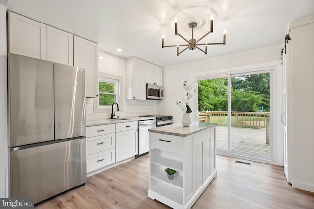 27136 Dogwood Ln, Mechanicsville, MD 20659 - kitchen featuring stainless steel appliances, a sink, white cabinetry, decorative backsplash, and a center island