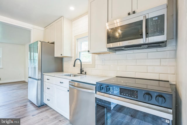 27136 Dogwood Ln, Mechanicsville, MD 20659 - kitchen with stainless steel appliances, a sink, light stone countertops, backsplash, and white cabinetry