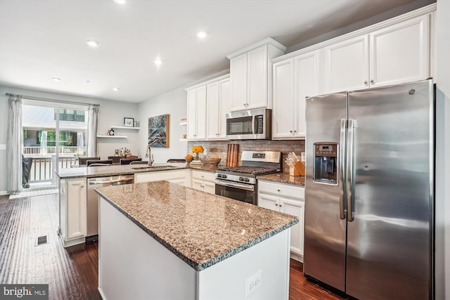 43436 Apple Orchard Sq, Ashburn, VA 20148 - kitchen featuring stainless steel appliances, a peninsula, dark wood-style flooring, a kitchen island, and stone countertops