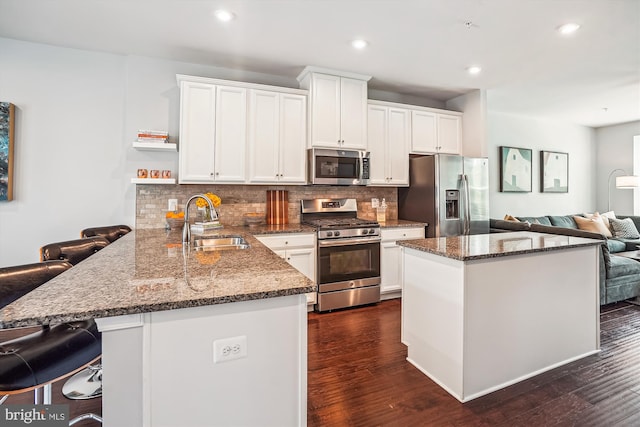 43436 Apple Orchard Sq, Ashburn, VA 20148 - kitchen with appliances with stainless steel finishes, tasteful backsplash, white cabinetry, a peninsula, and dark wood-style floors