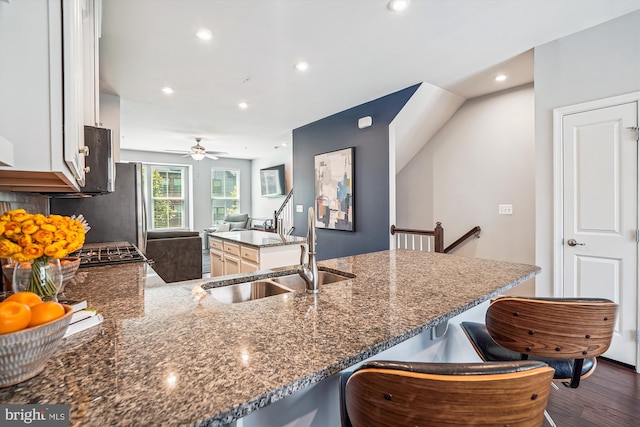 43436 Apple Orchard Sq, Ashburn, VA 20148 - kitchen with a breakfast bar, dark wood-type flooring, recessed lighting, dark stone counters, and a ceiling fan