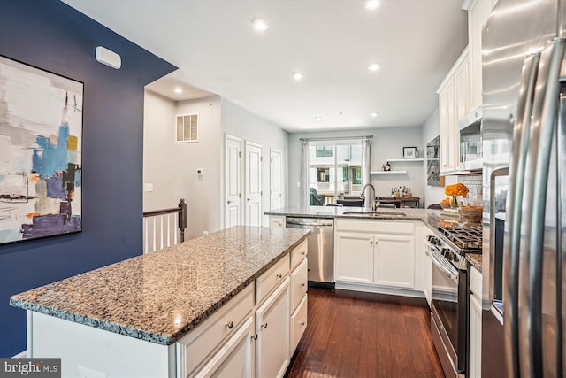 43436 Apple Orchard Sq, Ashburn, VA 20148 - kitchen featuring appliances with stainless steel finishes, a peninsula, dark wood-type flooring, light stone counters, and recessed lighting
