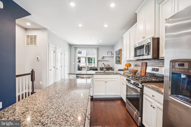 43436 Apple Orchard Sq, Ashburn, VA 20148 - kitchen with appliances with stainless steel finishes, light stone counters, a peninsula, recessed lighting, and white cabinetry