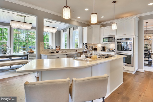 4420 Breidenbaugh Ln, Glen Arm, MD 21057 - kitchen featuring a chandelier, stainless steel appliances, light countertops, white cabinetry, and crown molding
