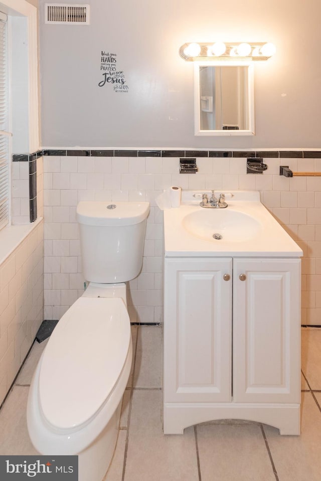 5603 Clearspring Rd, Baltimore, MD 21212 - half bathroom with tile walls, toilet, vanity, a wainscoted wall, and tile patterned flooring