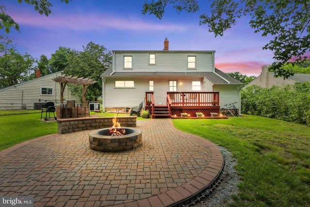 6937 Halleck St, District Heights, MD 20747 - back of property at dusk featuring an outdoor fire pit, a pergola, a wooden deck, and a patio