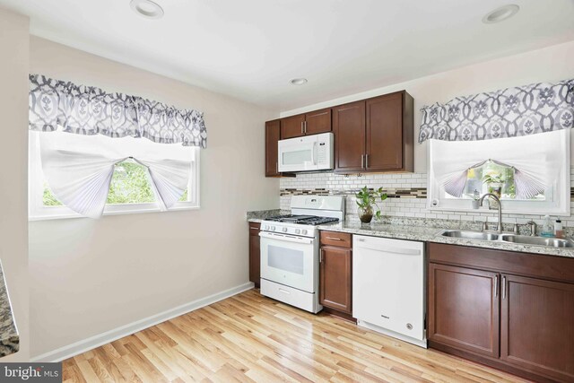 6937 Halleck St, District Heights, MD 20747 - kitchen featuring white appliances, decorative backsplash, light wood-style flooring, recessed lighting, and light stone countertops
