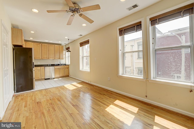 1030 Fairmont St NW Unit 204, Washington, DC 20001 - kitchen with stainless steel appliances, light wood finished floors, light brown cabinetry, dark countertops, and baseboards