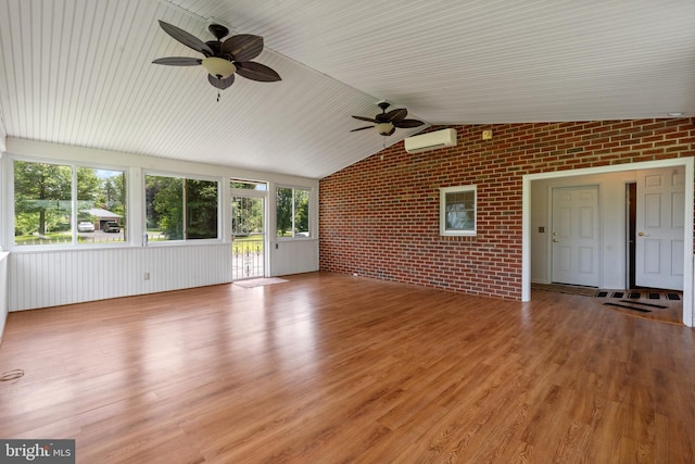 1404 Stockton Rd, Joppa, MD 21085 - unfurnished living room featuring brick wall, ceiling fan, an AC wall unit, plenty of natural light, and vaulted ceiling