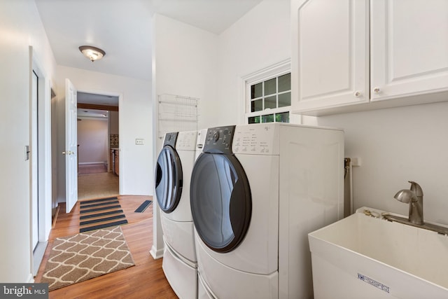 1404 Stockton Rd, Joppa, MD 21085 - laundry room with washer and dryer, light wood-style flooring, and cabinet space