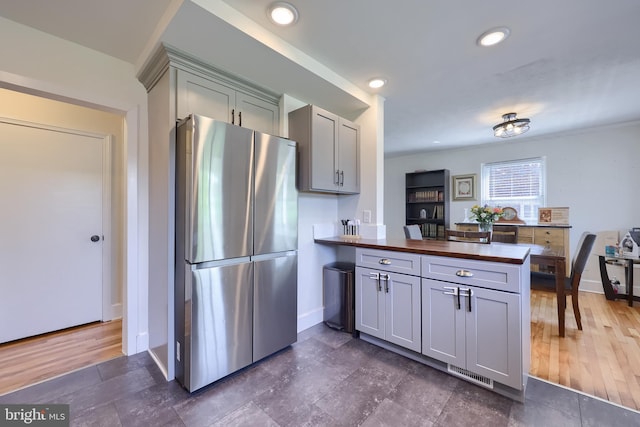 1304 Maple Ave, Lancaster, PA 17603 - kitchen featuring freestanding refrigerator, gray cabinetry, butcher block counters, a peninsula, and baseboards