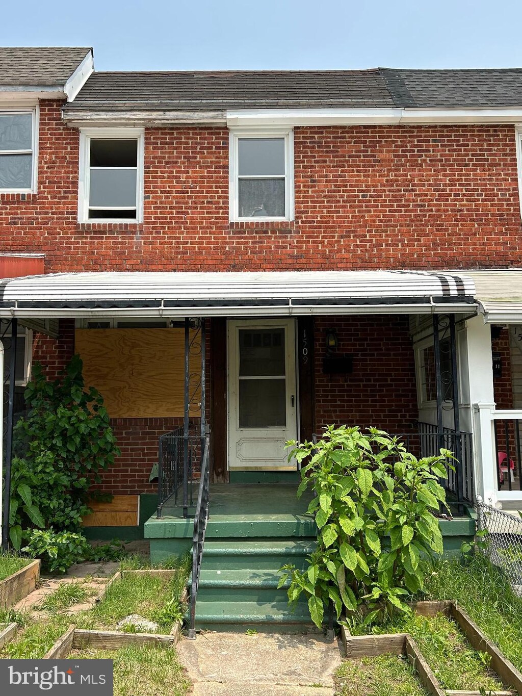1509 Charlotte Ave, Baltimore, MD 21224 - townhome / multi-family property with brick siding, a porch, and roof with shingles