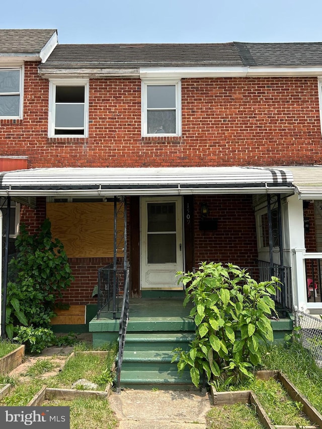 1509 Charlotte Ave, Baltimore, MD 21224 - townhome / multi-family property with brick siding, a porch, and roof with shingles