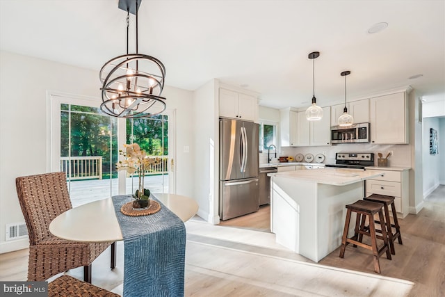 5202 Bayne Pl, Temple Hills, MD 20748 - kitchen featuring appliances with stainless steel finishes, a chandelier, light wood-type flooring, and light countertops