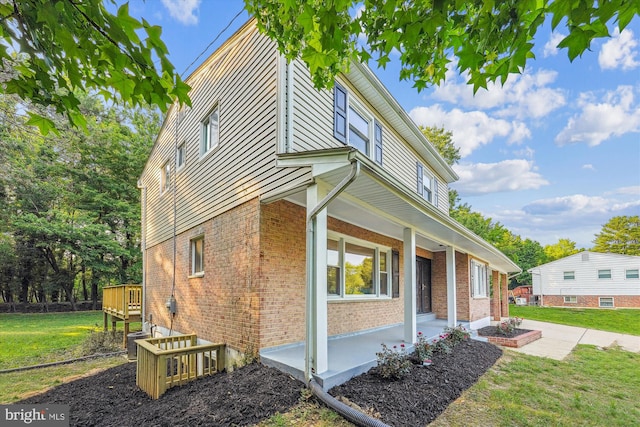 5202 Bayne Pl, Temple Hills, MD 20748 - view of home's exterior with brick siding, a porch, a yard, and central AC unit