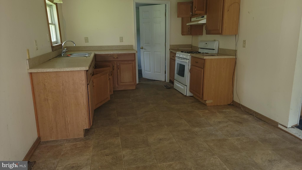 22333 Colton Point Rd, Bushwood, MD 20618 - kitchen featuring white gas range oven, under cabinet range hood, a sink, light countertops, and baseboards