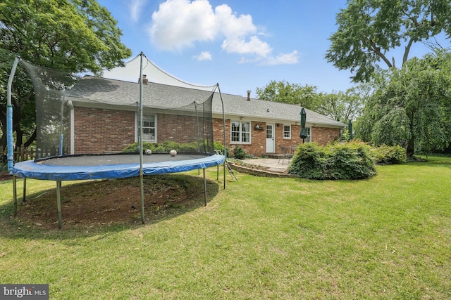 6622 Skyline Ct, Alexandria, VA 22307 - back of property featuring a trampoline, a lawn, brick siding, and a patio