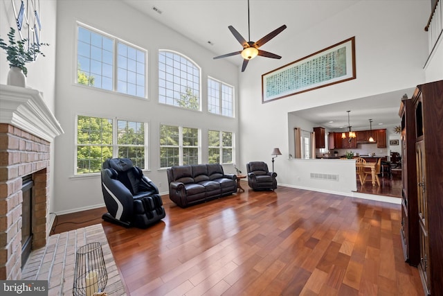 915 Mather Dr, Bear, DE 19701 - living room with a high ceiling, a fireplace, a ceiling fan, dark wood-type flooring, and healthy amount of natural light