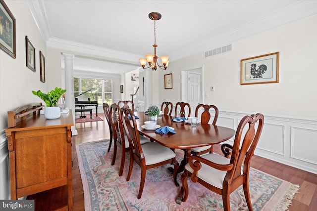 915 Mather Dr, Bear, DE 19701 - dining space with crown molding, a chandelier, wood finished floors, a wainscoted wall, and ornate columns