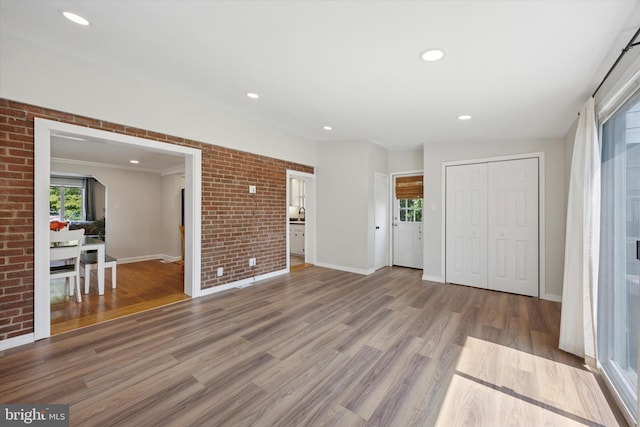 2120 Grand Ave, Morton, PA 19070 - unfurnished living room featuring wood finished floors, baseboards, brick wall, and recessed lighting