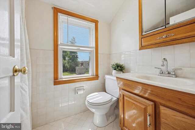 2120 Grand Ave, Morton, PA 19070 - bathroom featuring tile walls, tile patterned floors, toilet, vanity, and lofted ceiling