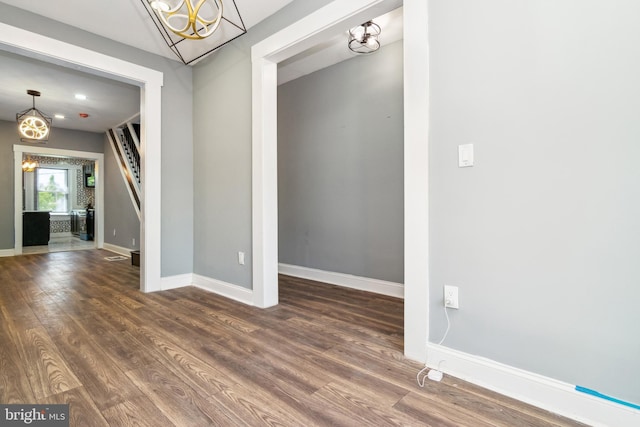 2525 W Lombard St, Baltimore, MD 21223 - empty room with a chandelier, wood finished floors, and baseboards