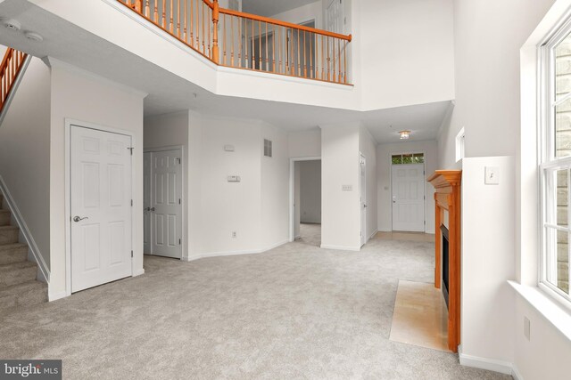 542 June Apple Ct, Abingdon, MD 21009 - unfurnished living room with a high ceiling, stairway, carpet flooring, and healthy amount of natural light