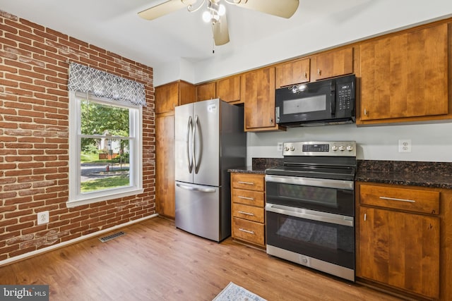 8485 Laurel Oak Dr, Springfield, VA 22153 - kitchen with stainless steel appliances, brick wall, brown cabinetry, a ceiling fan, and light wood finished floors