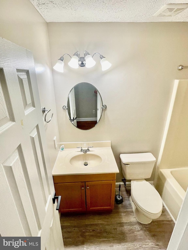 25795 Shamrock Ln, Mechanicsville, MD 20659 - full bath with vanity, toilet, wood finished floors, a textured ceiling, and baseboards