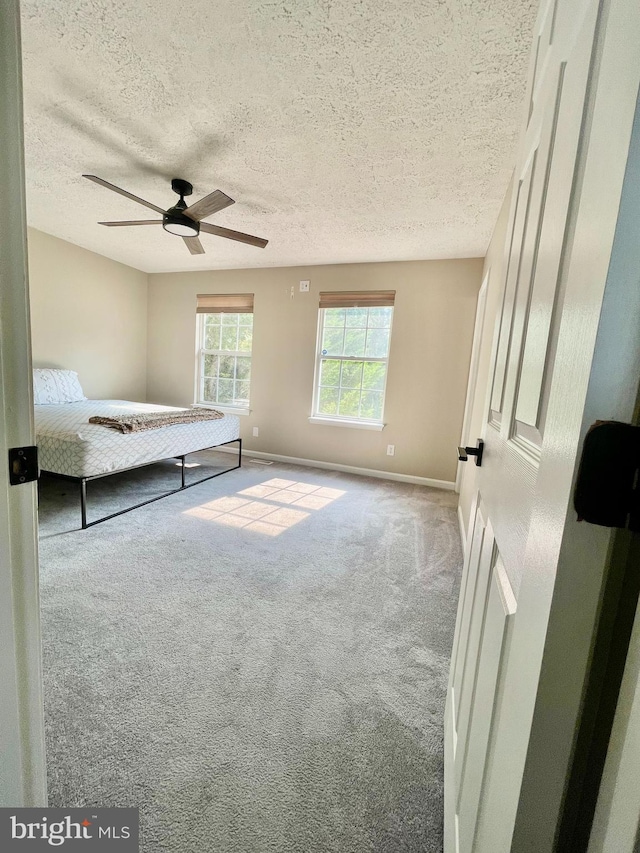 25795 Shamrock Ln, Mechanicsville, MD 20659 - unfurnished bedroom featuring carpet, a textured ceiling, baseboards, and a ceiling fan