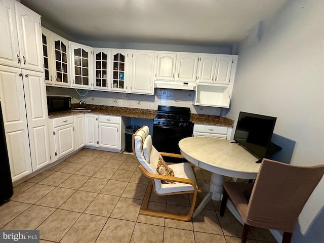1707 Harman Ave, Baltimore, MD 21230 - kitchen featuring black appliances, under cabinet range hood, white cabinets, dark countertops, and glass insert cabinets