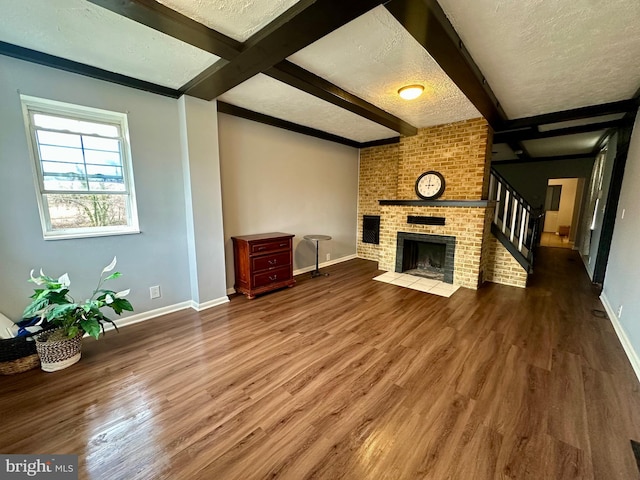 1707 Harman Ave, Baltimore, MD 21230 - unfurnished living room with a textured ceiling, wood finished floors, beamed ceiling, baseboards, and stairs