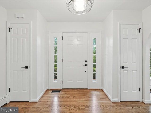 2500 Sams Creek Rd, Westminster, MD 21157 - entrance foyer featuring plenty of natural light, light wood-style floors, a baseboard radiator, and arched walkways