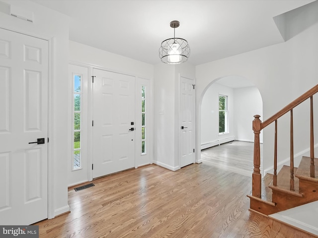2500 Sams Creek Rd, Westminster, MD 21157 - entrance foyer featuring arched walkways, light wood-style floors, stairway, and baseboard heating