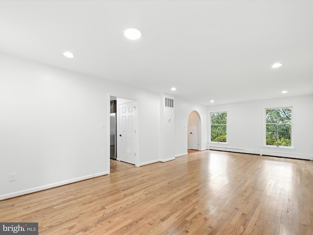 2500 Sams Creek Rd, Westminster, MD 21157 - unfurnished living room with arched walkways, baseboard heating, recessed lighting, and light wood finished floors