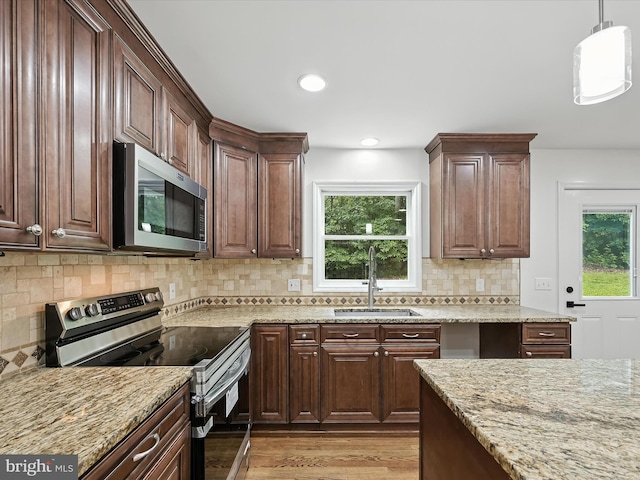 2500 Sams Creek Rd, Westminster, MD 21157 - kitchen featuring appliances with stainless steel finishes, light stone counters, light wood-style floors, backsplash, and hanging light fixtures