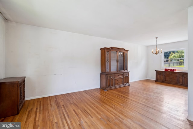 10520 Truxton Rd, Hyattsville, MD 20783 - unfurnished living room with a chandelier, light wood-style flooring, and baseboards
