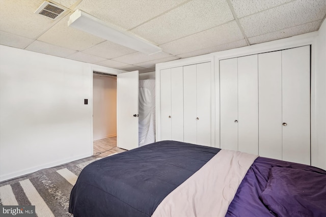 10520 Truxton Rd, Hyattsville, MD 20783 - bedroom with a drop ceiling, multiple closets, baseboards, and light wood-style flooring