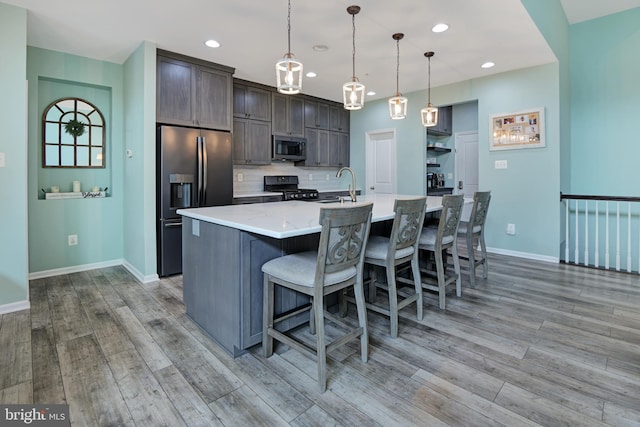 2017 Chamberlain Dr, Frederick, MD 21702 - kitchen featuring fridge with ice dispenser, black range with gas cooktop, stainless steel microwave, light wood finished floors, and recessed lighting