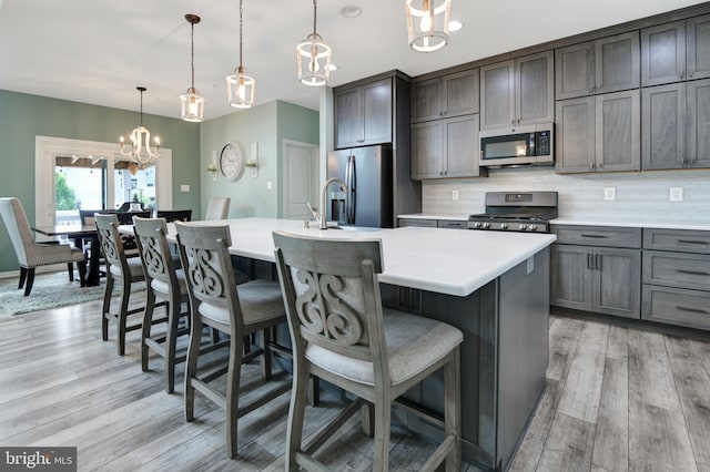 2017 Chamberlain Dr, Frederick, MD 21702 - kitchen featuring stainless steel appliances, a chandelier, tasteful backsplash, light countertops, and a kitchen island with sink