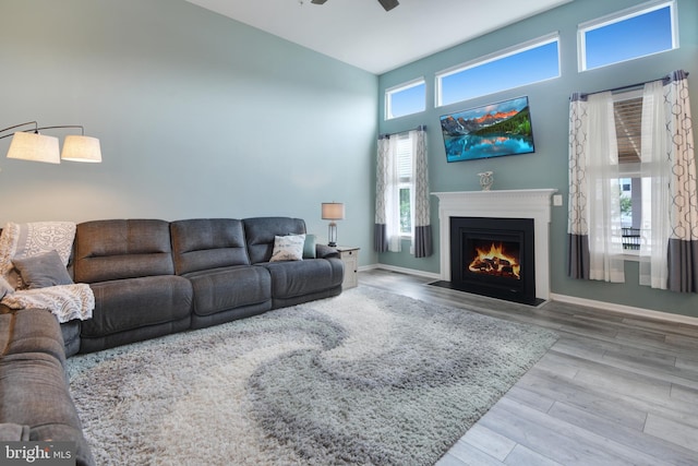 2017 Chamberlain Dr, Frederick, MD 21702 - living room featuring a fireplace with flush hearth, wood finished floors, high vaulted ceiling, ceiling fan, and baseboards