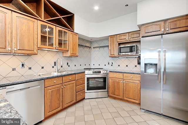 1805 Crystal Dr Unit 1110S, Arlington, VA 22202 - kitchen featuring appliances with stainless steel finishes, light tile patterned floors, tasteful backsplash, brown cabinets, and glass insert cabinets