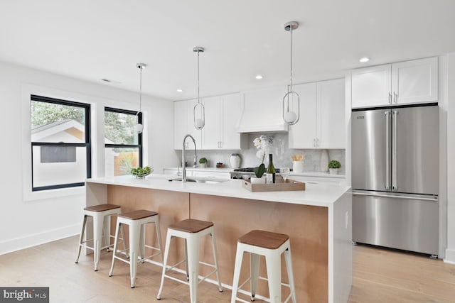 4324 Yuma St NW, Washington, DC 20016 - kitchen with high quality fridge, tasteful backsplash, white cabinets, light countertops, and a kitchen island with sink
