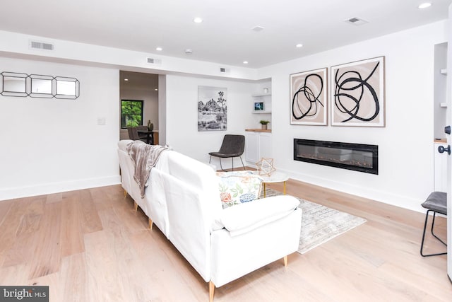 4324 Yuma St NW, Washington, DC 20016 - living room featuring a glass covered fireplace, light wood finished floors, recessed lighting, and baseboards