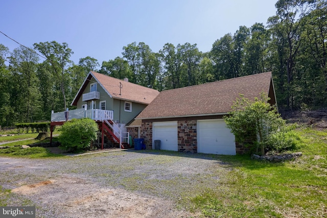402 Swamp Rd, Morgantown, PA 19543 - view of front of house with stairway, driveway, a wooden deck, stone siding, and roof with shingles